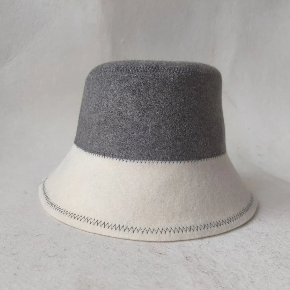 Bastuhatt i bucket-modell med logotyp